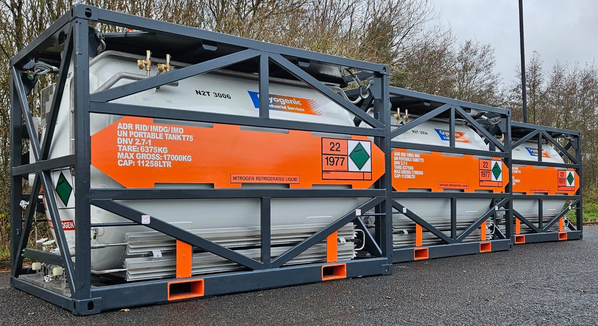 Three CIS Gases T75 cryogenic ISO tank containers in dark frames, lined up